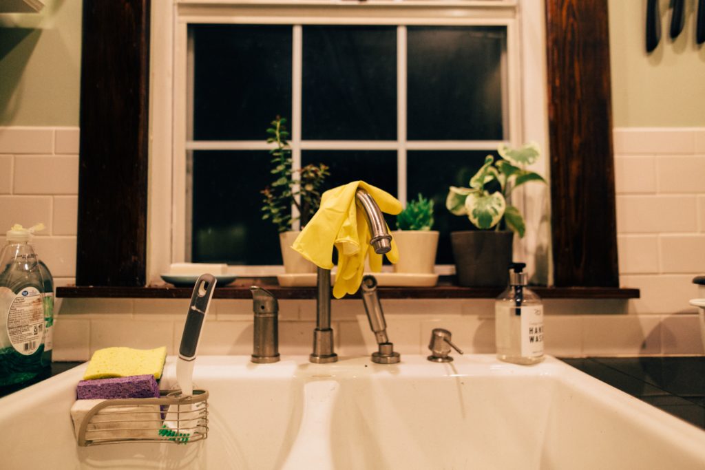 Kitchen sink with rubber gloves and cleaning supplies