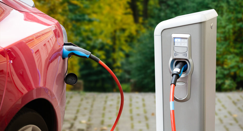 Red Electric Vehicle being charged by an EV Charging Station