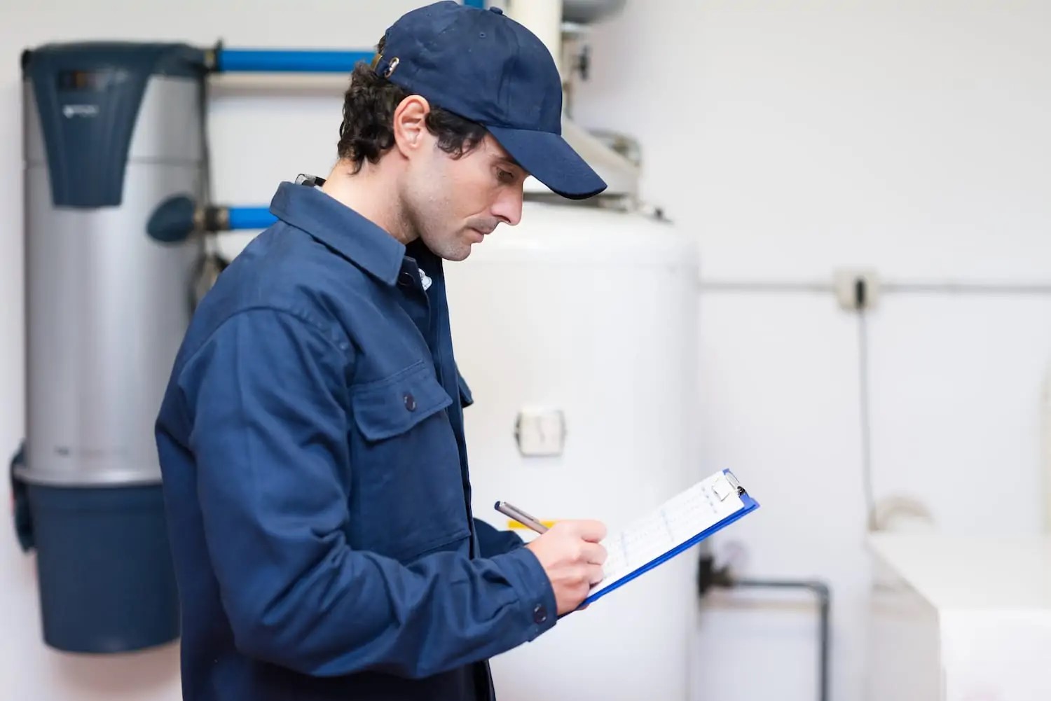 plumber with clipboard in front of newly installed water heater